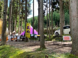 木々の間に複数の屋台が並び、ノボリがはためいている。