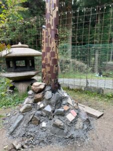 木の周りに様々な形の石を積み上げたオブジェ